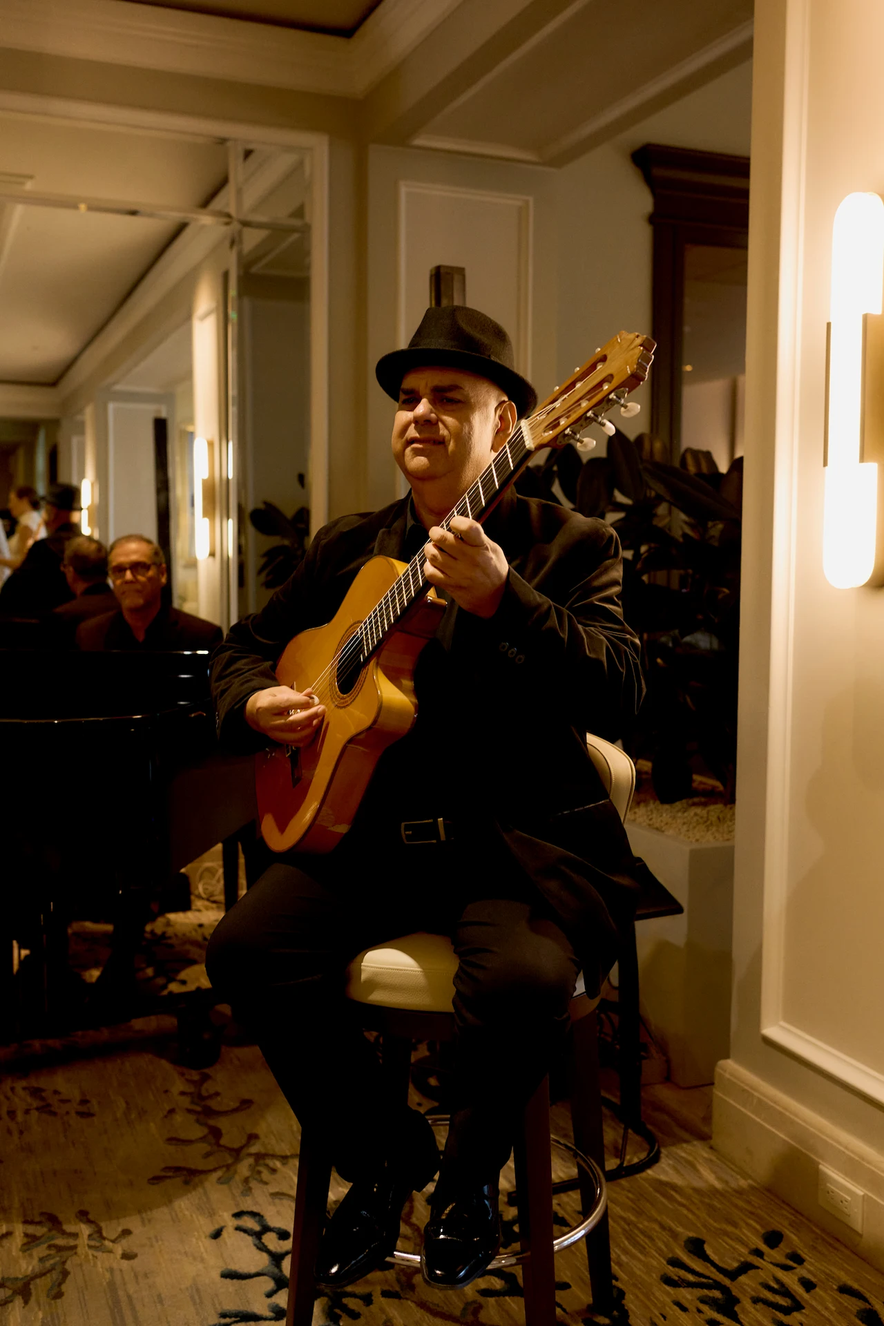 Live guitar and piano performance in a warmly lit lounge, creating a refined and intimate atmosphere