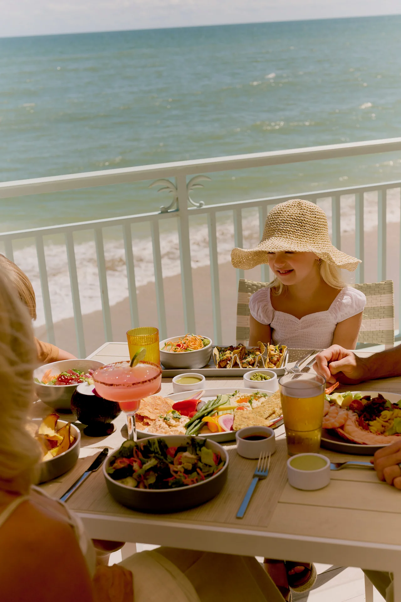 Family enjoying colorful coastal lunch at breeze ocean kitchen with ocean views at eau palm beach