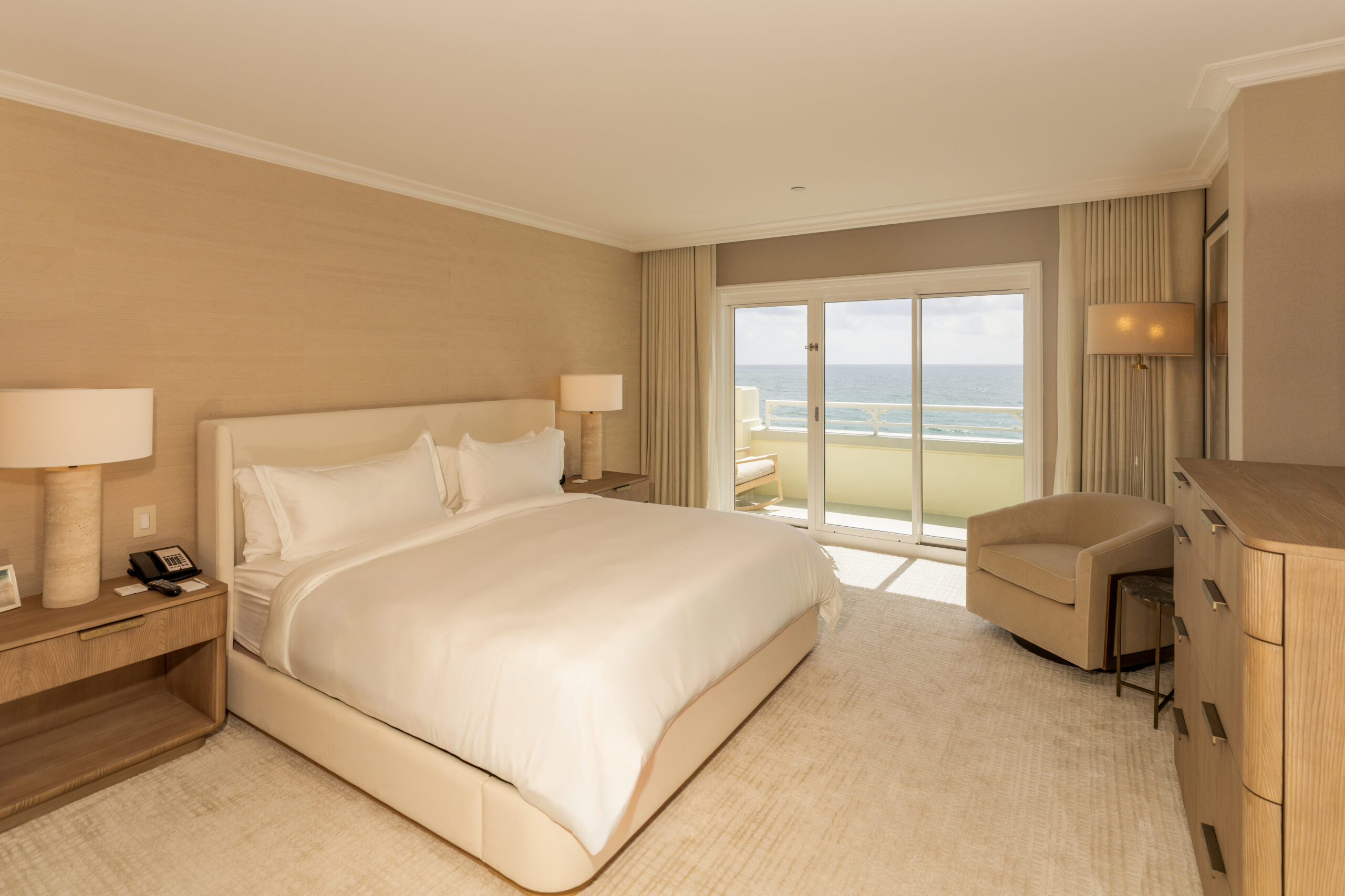 Elegant beachfront hotel room with king bed and balcony overlooking the ocean