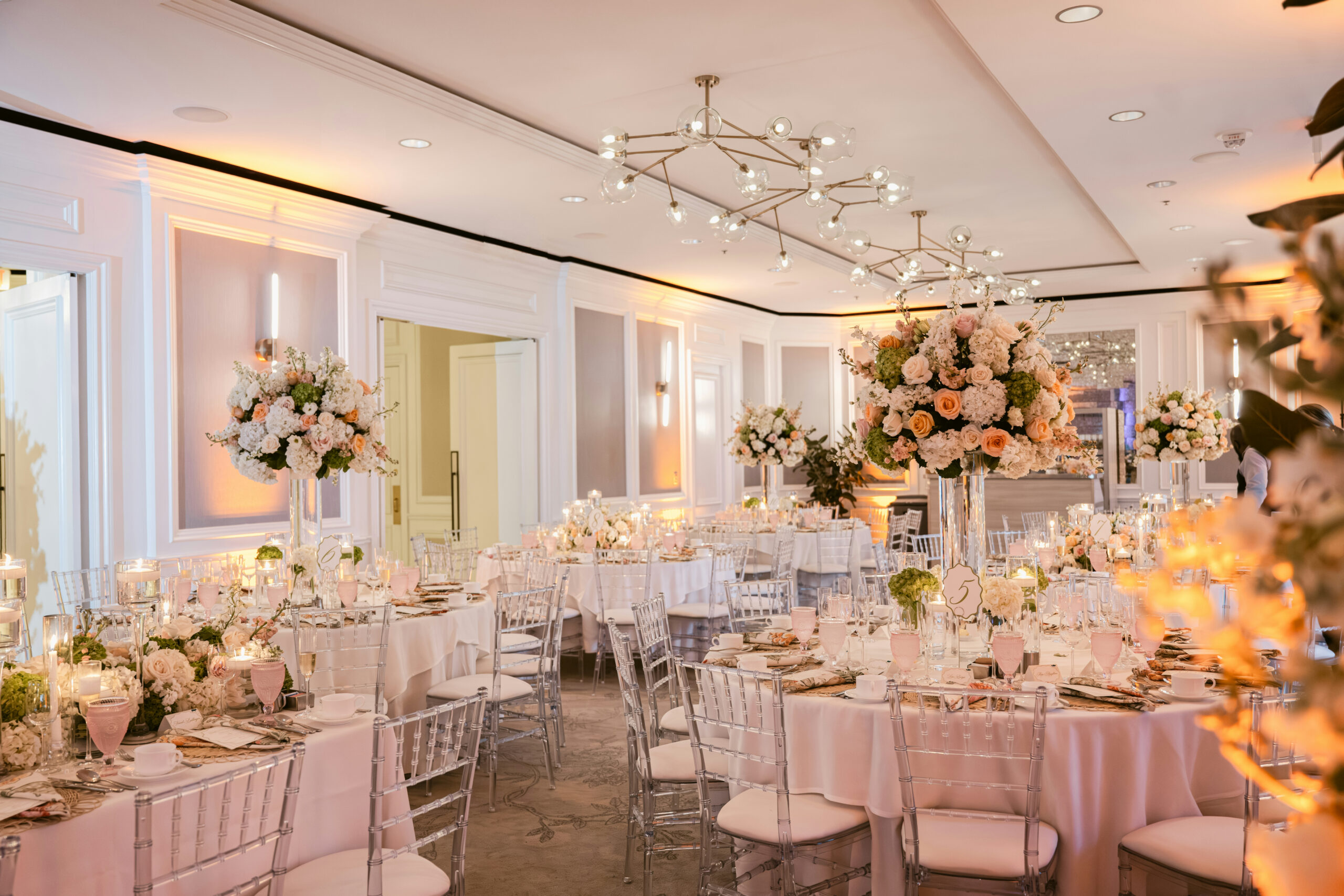 Elegant banquet hall with floral centerpieces, round tables, and soft candlelit decor