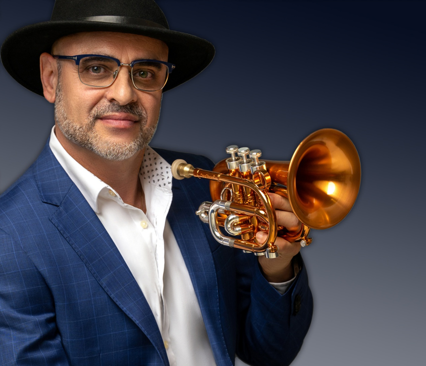 Bill colletti holding a flugelhorn while posing in a blue checkered suit and hat.