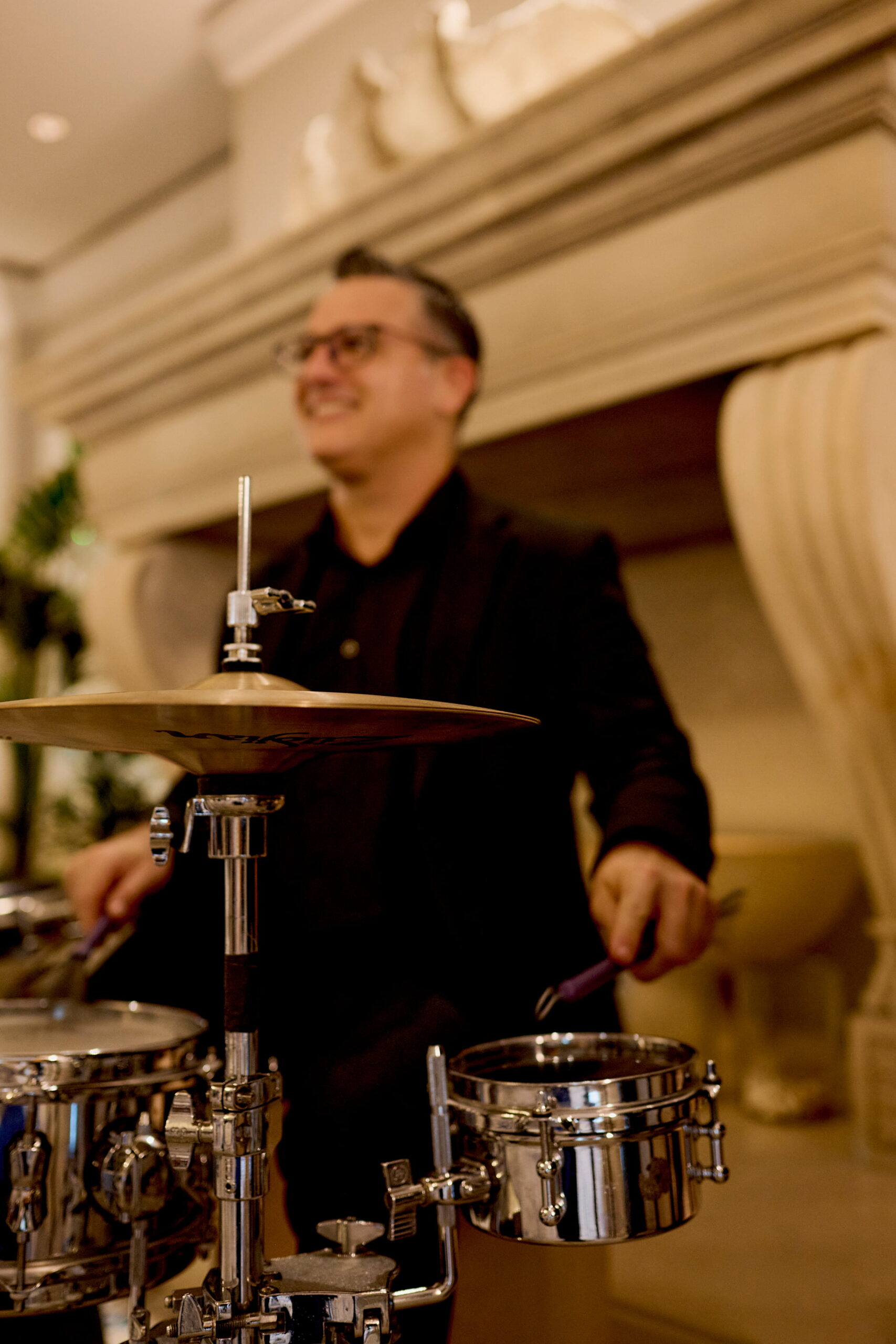 Smiling drummer playing percussion set at elegant indoor event venue